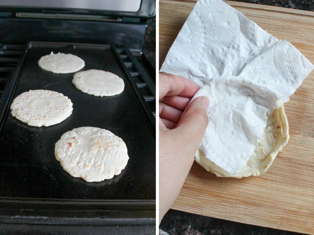 Masa discs cooking on a warm griddle then pinched at the edges to create a wall around the discs.