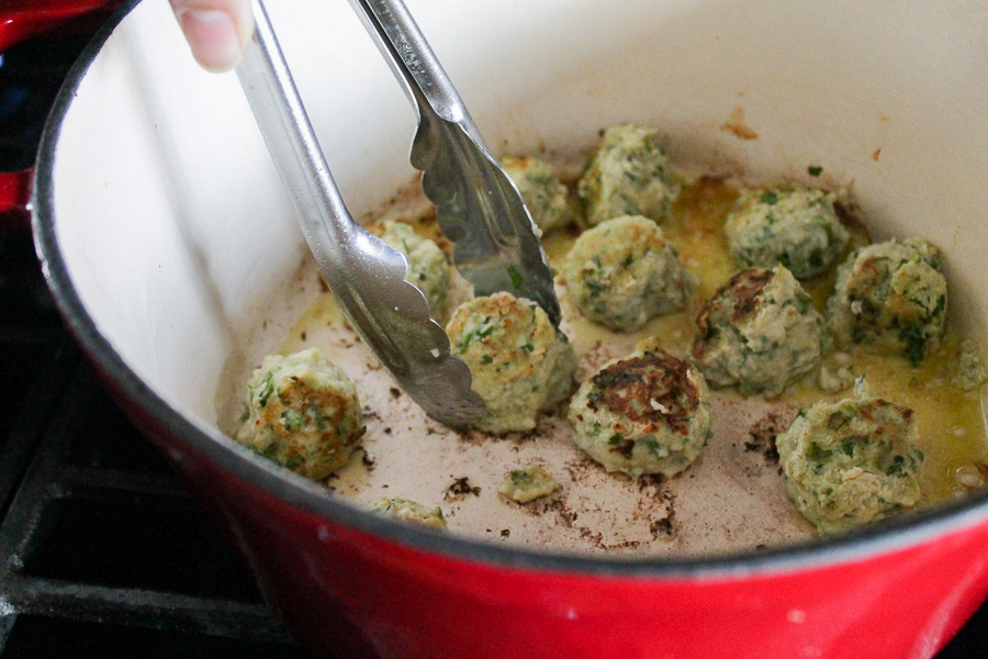 Turkey meatballs being cooked in a dutch oven pot.