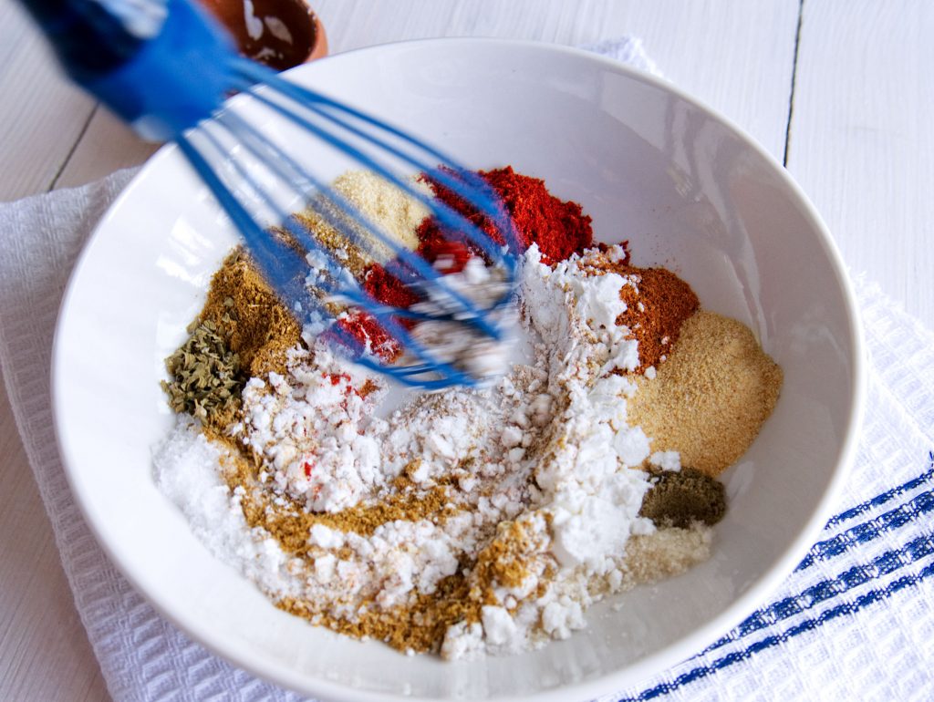 A close-up photo of taco seasoning being mixed in a bowl.