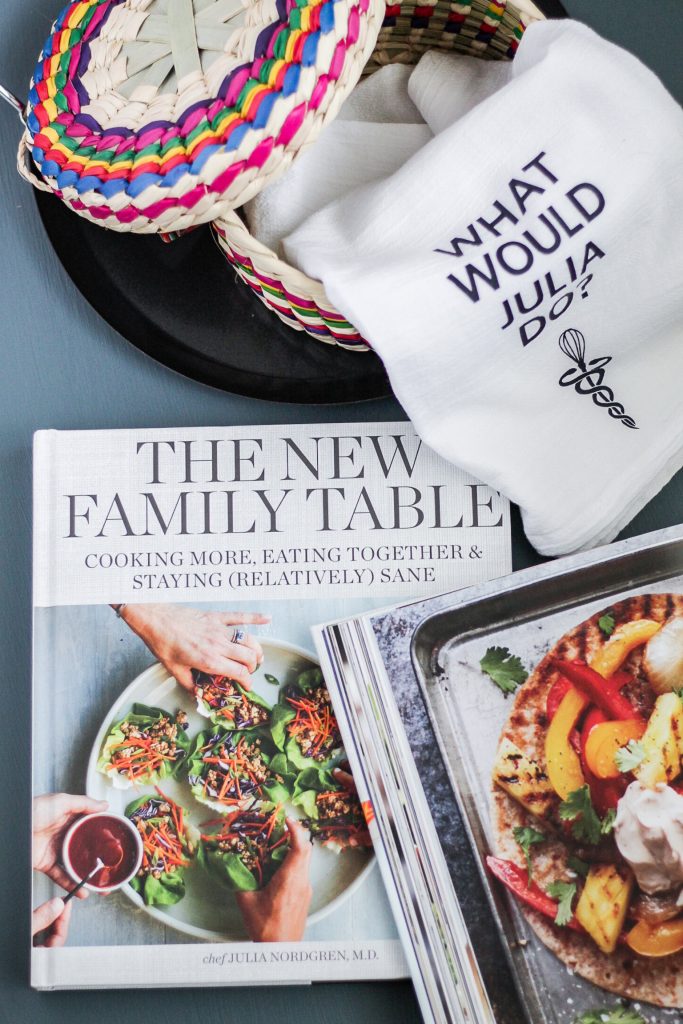 Dish towel, colorful tortilla warmer with lid, round griddle, and two copies of Dr. Julia Nordgren's cookbook The New Family Table: Cooking more, eating together and staying relatively sane. 